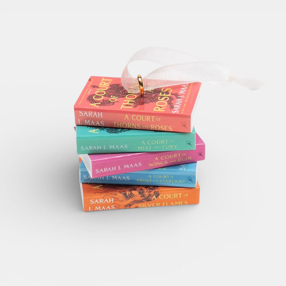 Ornament featuring mini stack of books by Sarah J. Maas on a white background