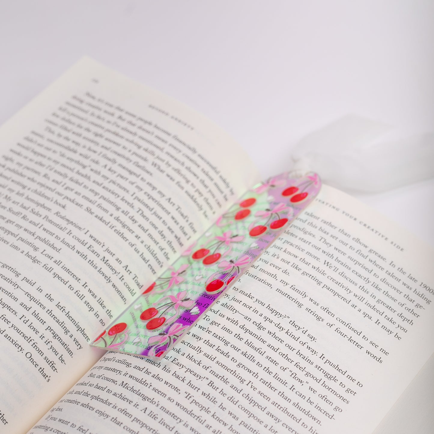 Holographic bookmark with cherries on an open book