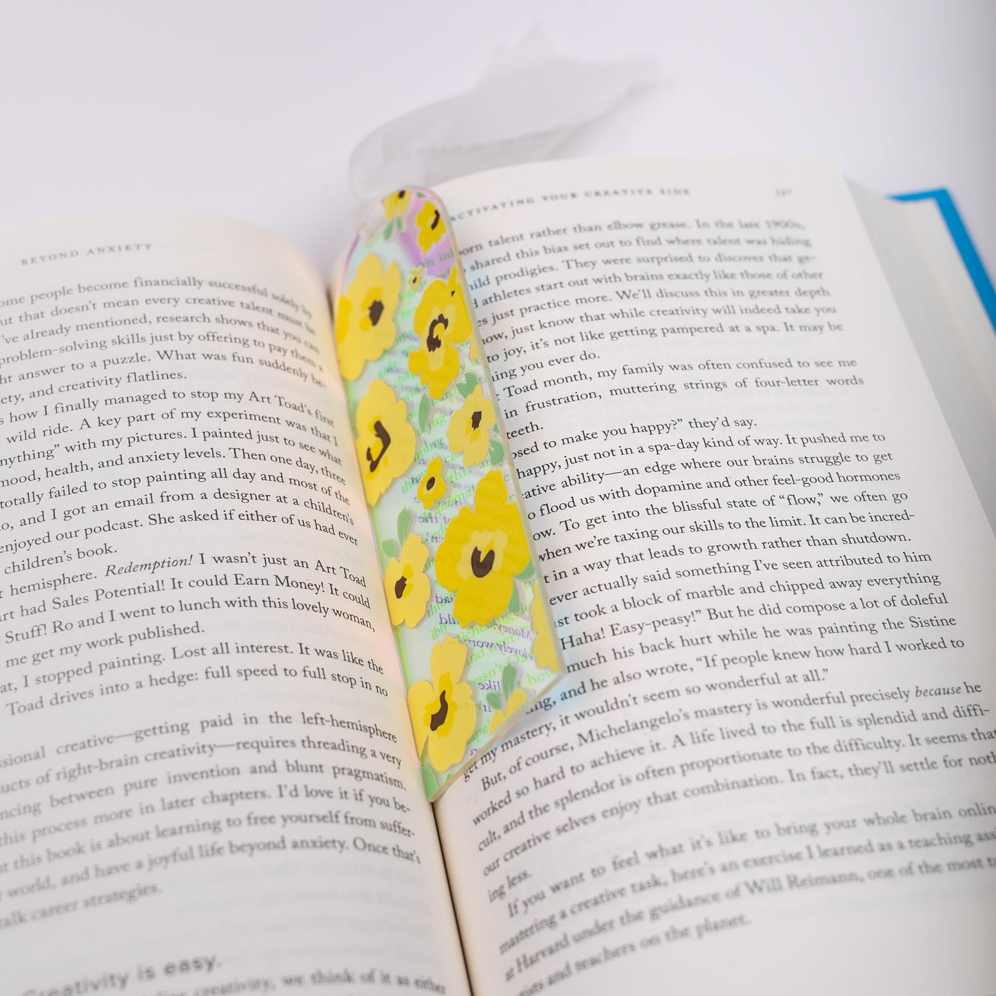 Open book with a floral holographic bookmark on a white background
