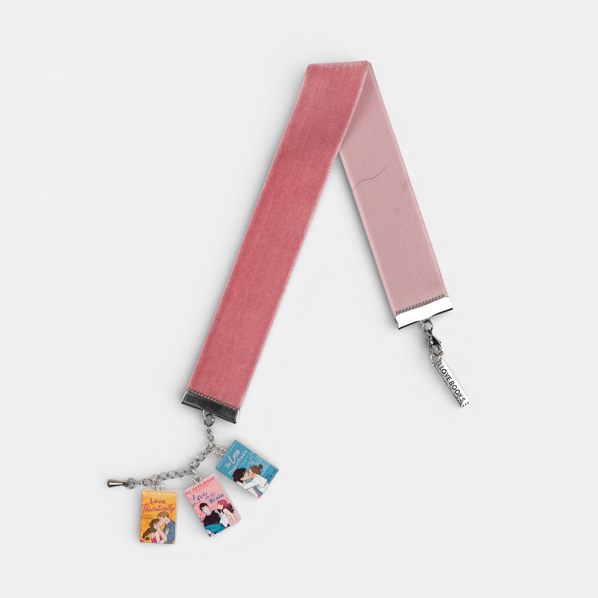Pink, velvet ribbon bookmark with mini charms of Ali Hazelwood's books on a white background