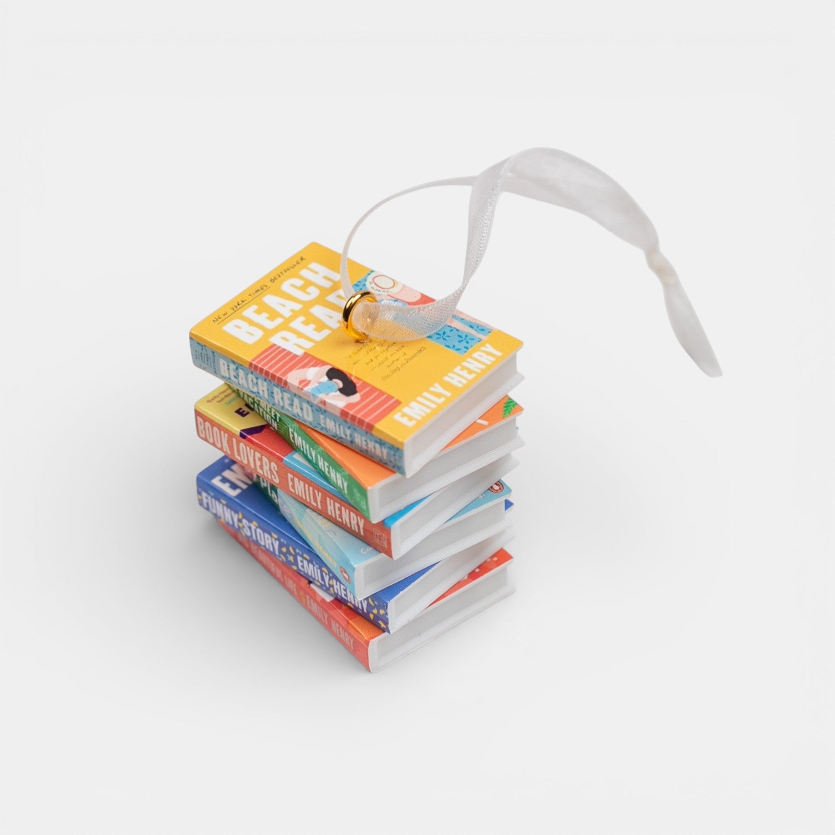 Ornament featuring a mini stack of Emily Henry books with a decorative ribbon on a white background