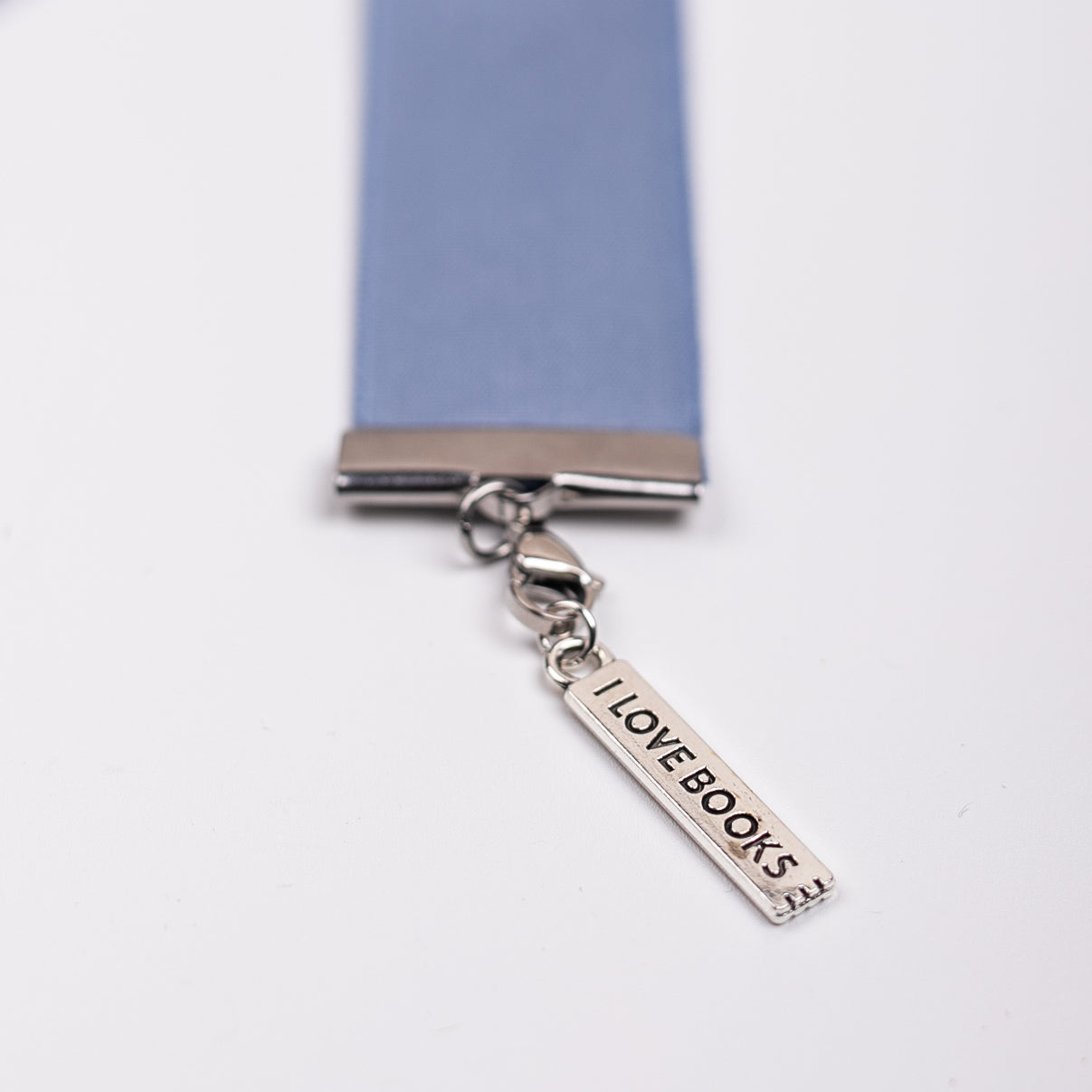 Blue ribbon with an 'I LOVE BOOKS' charm on a white background