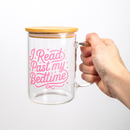 Glass mug with bamboo lid held by a hand, featuring pink text on a white background