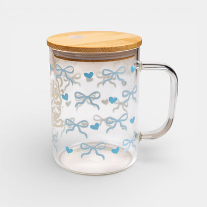 Clear mug with blue bow pattern and bamboo lid on a white background