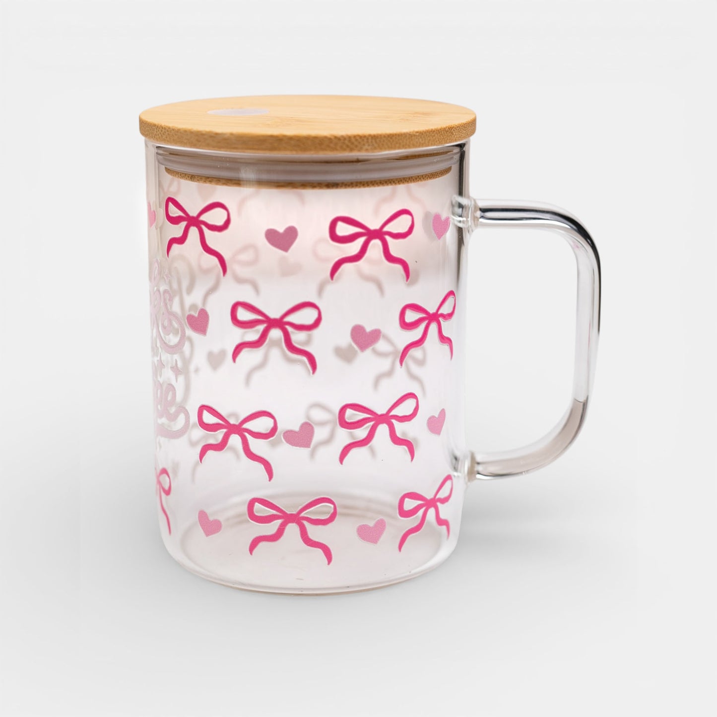 Glass mug with pink bow pattern, bamboo lid, and handle on a white background