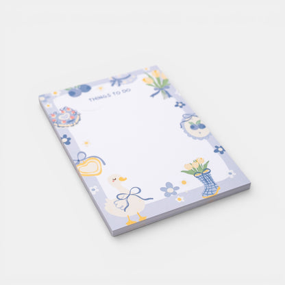 Notepad with decorative border and illustrations on a white background