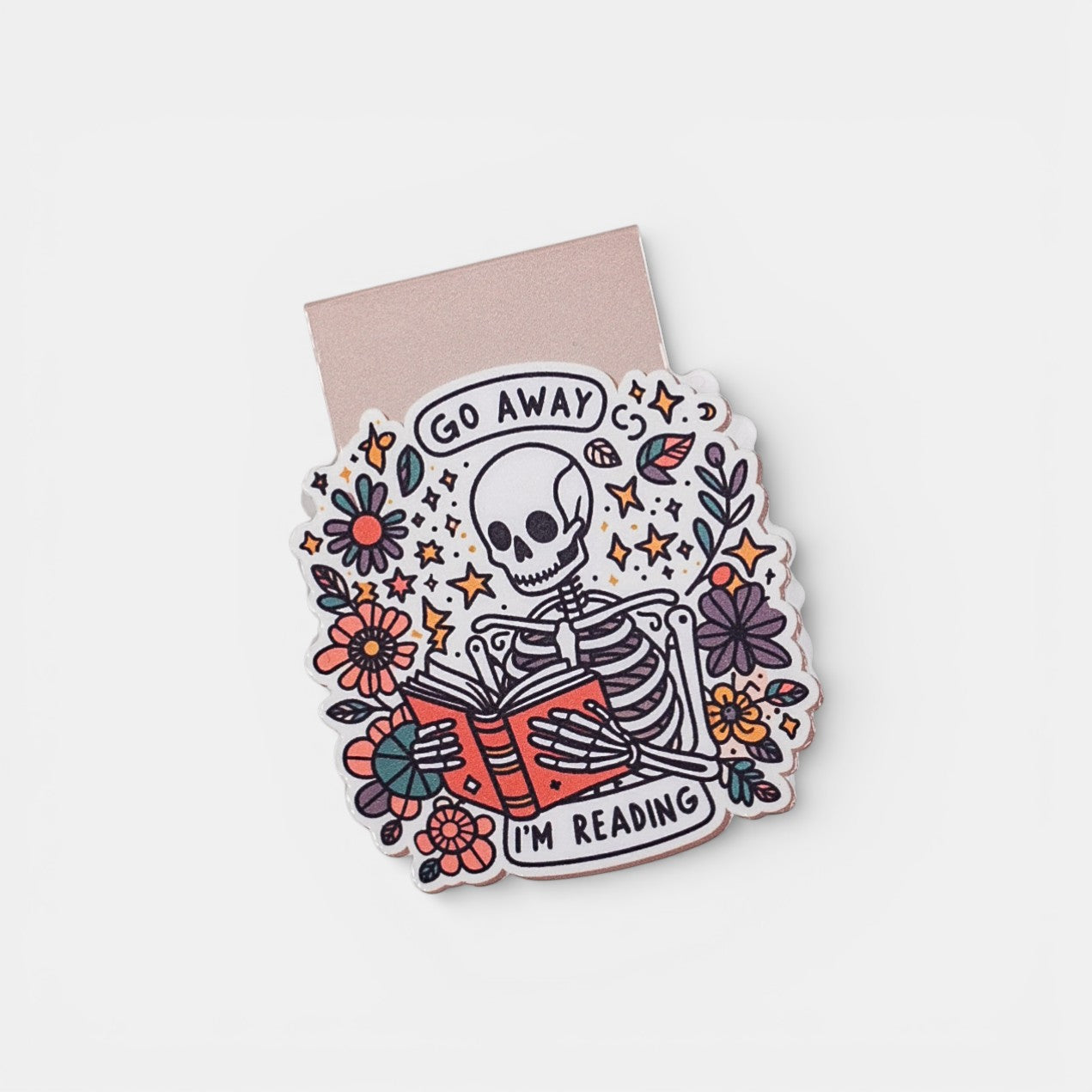 Bookmark with skeleton reading a book and flowers, text 'Go Away I'm Reading', on a white background.