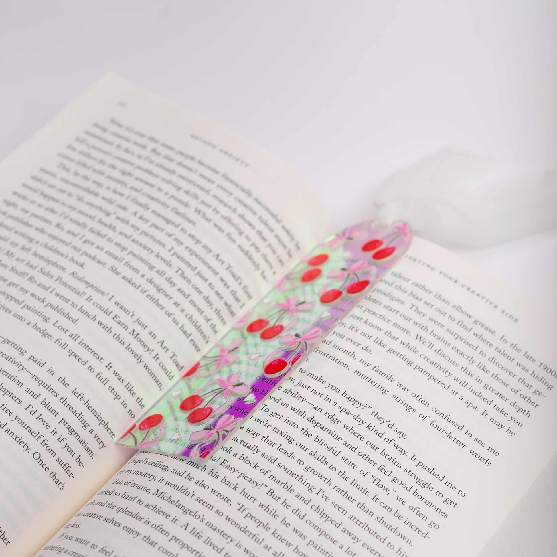 Holographic bookmark with cherries on an open book