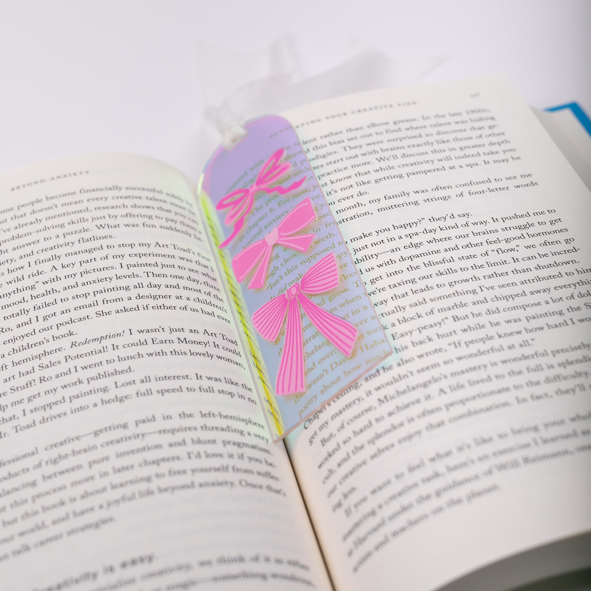 Open book with a colorful holographic bookmark on a white background