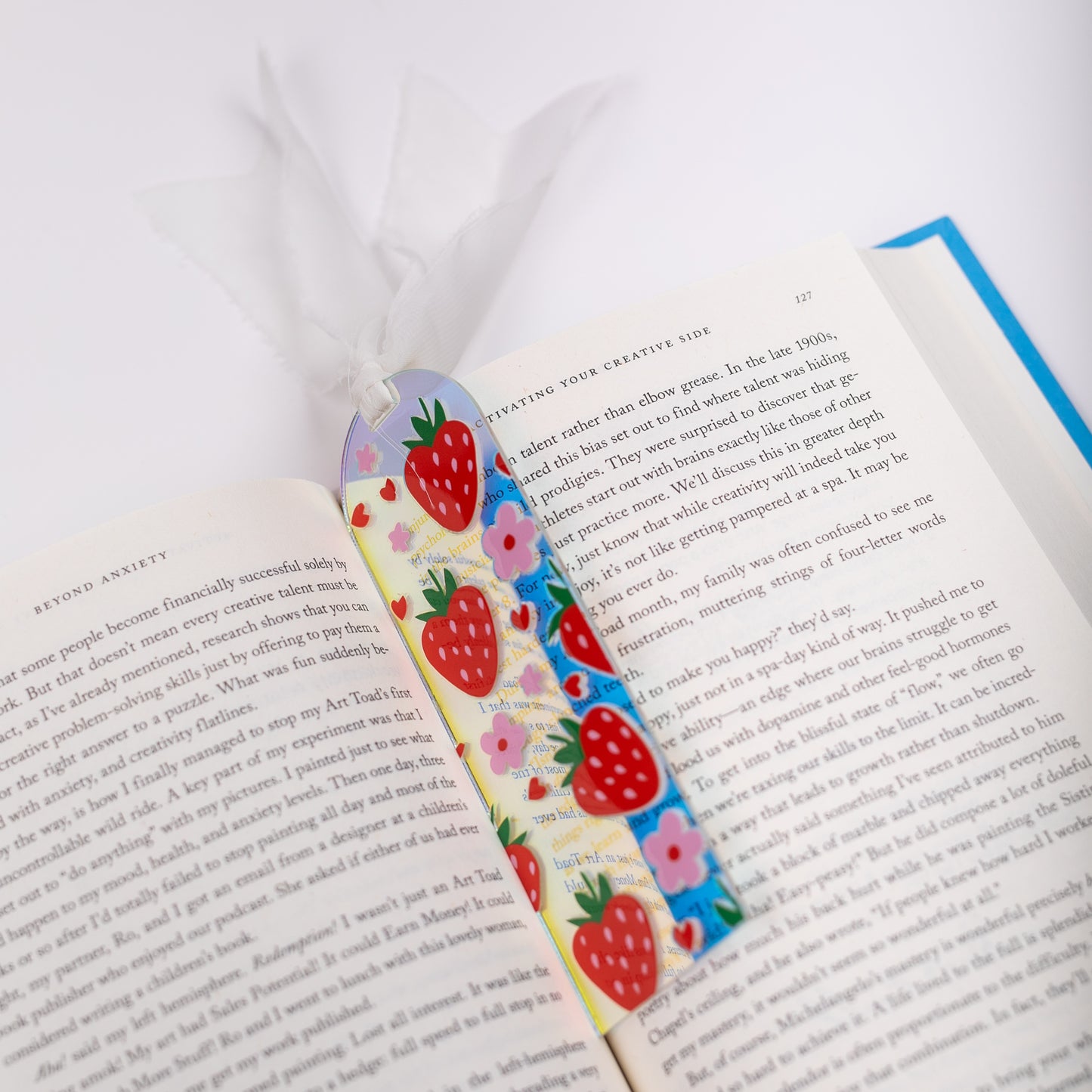 Colorful strawberry-themed bookmark on an open book