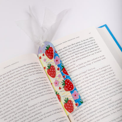 Colorful strawberry-themed bookmark on an open book