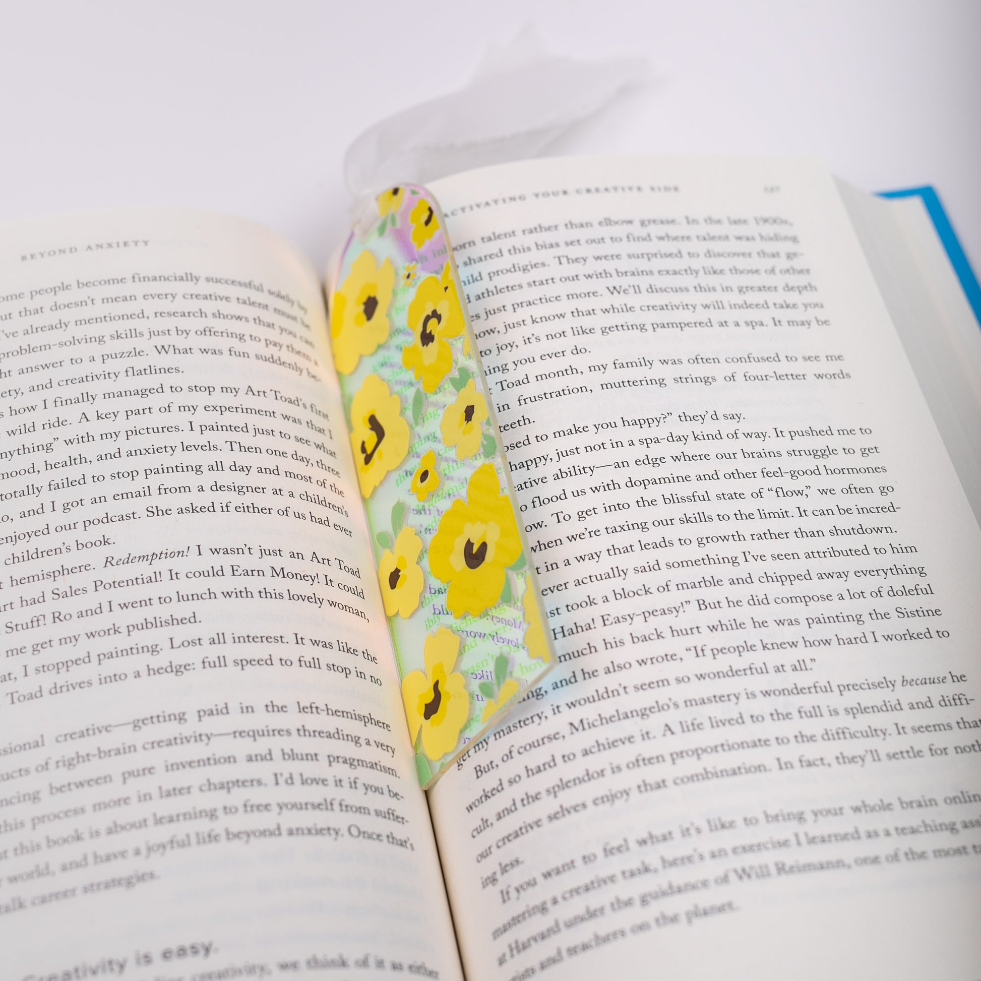 Open book with a floral holographic bookmark on a white background
