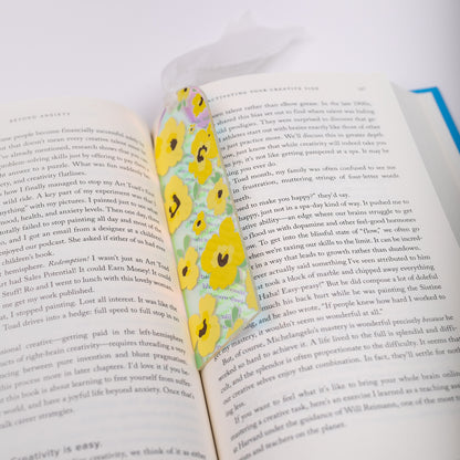 Open book with a floral holographic bookmark on a white background