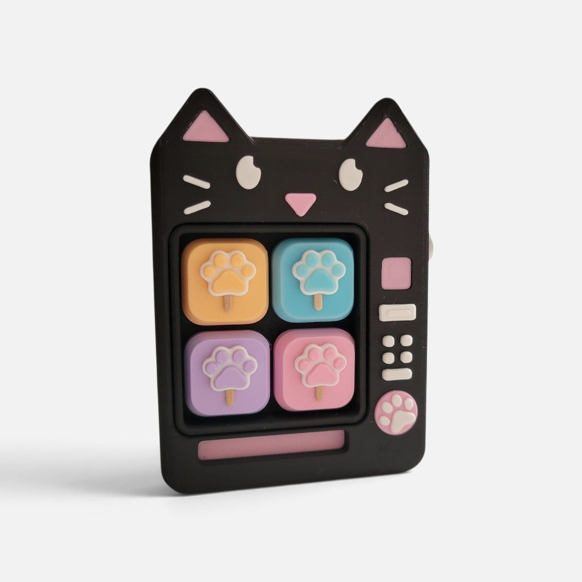 The Salty Cat Co black cat-shaped mechanical fidget toy with pastel paw-print buttons and retro television design.