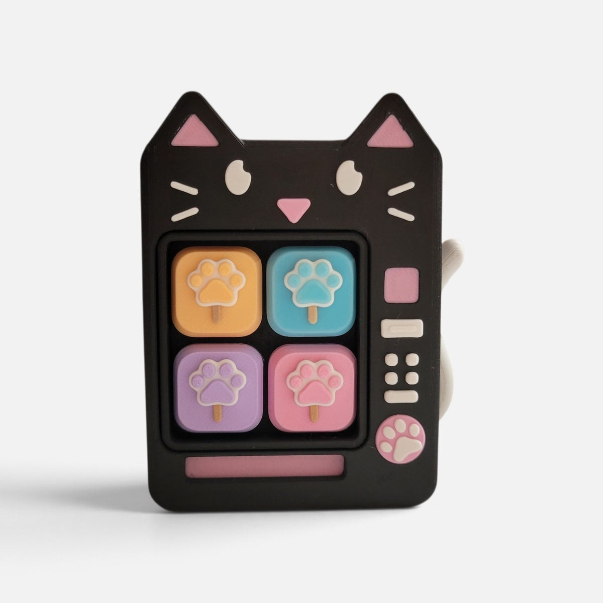 The Salty Cat Co black cat shaped fidget toy with pastel paw print buttons and a retro vending machine design.