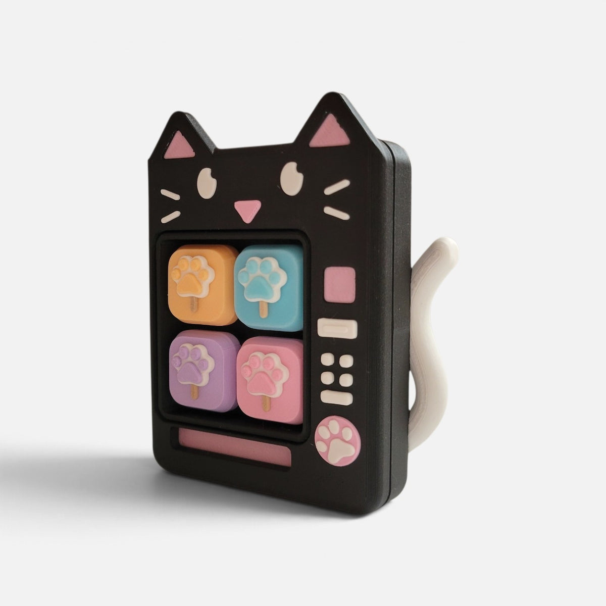 The Salty Cat Co black cat shaped mechanical fidget toy with pastel paw print buttons and a white tail accent.